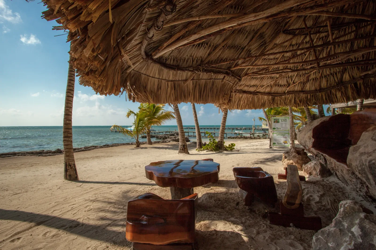 Palm-fringed pool and thatched palapas at Xanadu Island Resort in San Pedro, Belize.