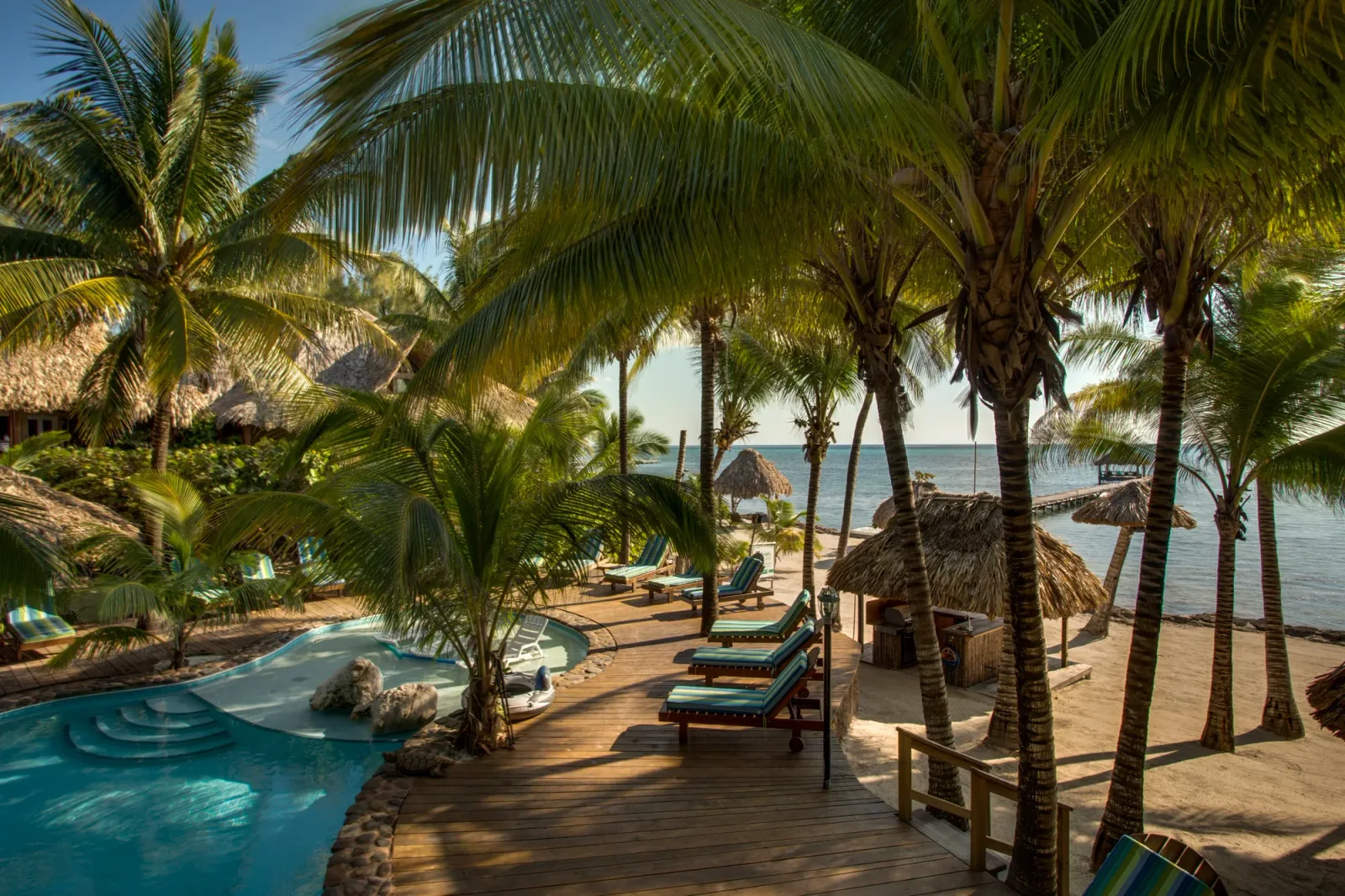 Morning sun across the pool deck, palms and beachfront at Xanadu Island Resort.