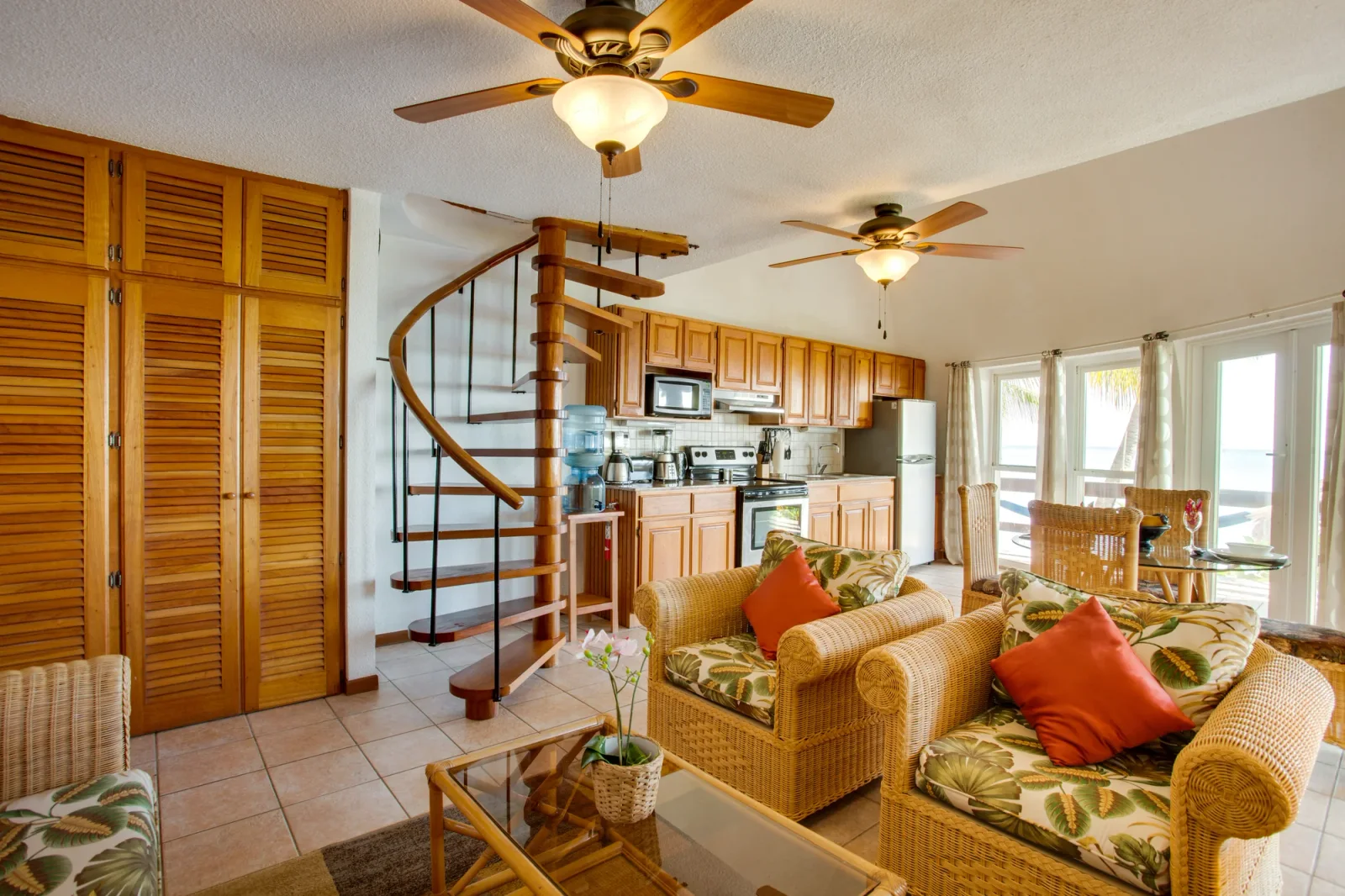 Oceanfront loft suite living area with a spiral staircase and full kitchen at Xanadu.