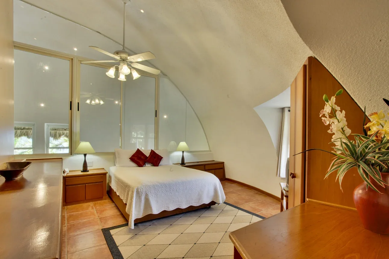 Air-conditioned loft suite bedroom with vaulted ceiling at Xanadu Island Resort.